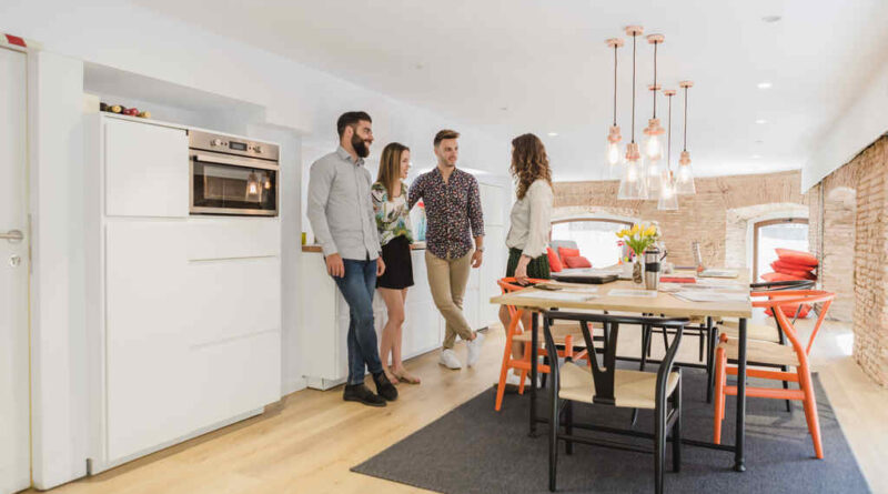 amigos reunidos conversando em pé na sala de jantar de um apartamento